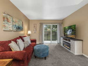 Carpeted living room featuring a glass covered fireplace