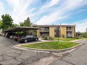 View of building exterior featuring covered parking