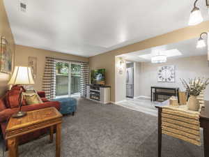 Living area featuring a lit fireplace and light carpet