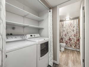 Washroom featuring light wood-style floors and separate washer and dryer