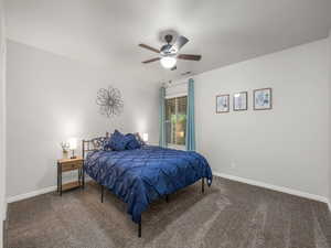 Bedroom with dark carpet and ceiling fan