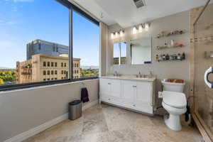 Bathroom featuring plenty of natural light, double vanity, travertine marble throughout and a mountain view