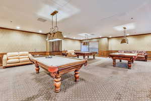 Recreation room featuring wallpapered walls, ornamental molding, billiards table, carpet floors, and a wainscoted wall