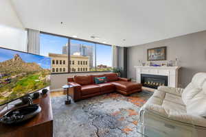 Living room with a glass covered electric fireplace and wood finished floors