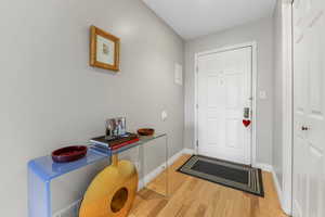 Foyer entrance featuring light hard wood laminate floors and baseboards
