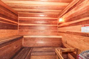 Relaxing sauna featuring wood ceiling and wood walls