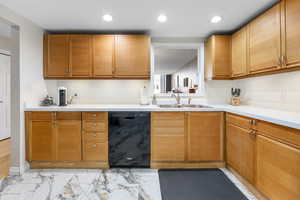 Kitchen with black dishwasher, light countertops, light marble finish flooring, recessed lighting, and tan cabinetry