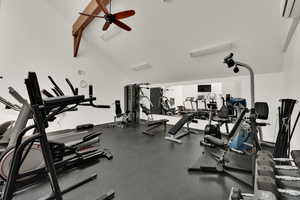 Gym with a wall unit AC, a ceiling fan, and high vaulted ceiling