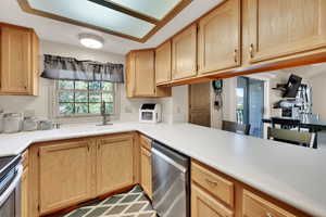 Kitchen featuring light brown cabinetry, stainless steel appliances, and light countertops