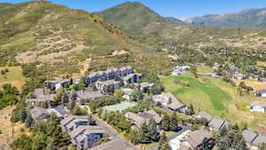 Aerial view of property and surrounding area featuring nearby suburban area and mountains