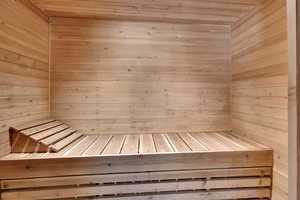 Relaxing sauna featuring wooden walls and wooden ceiling