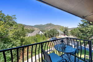 Balcony with a mountain view and view of wooded area