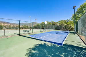 View of tennis court featuring community basketball court and a mountain view