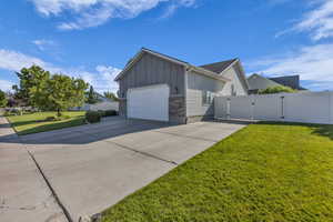 View of front of house featuring a gate, driveway, board and batten siding, a garage, and brick siding