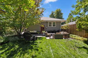 Rear view of house with outdoor lounge area, a patio area, brick siding, and a fenced backyard