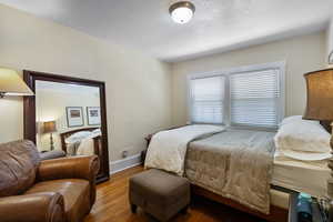 Bedroom featuring wood finished floors and baseboards