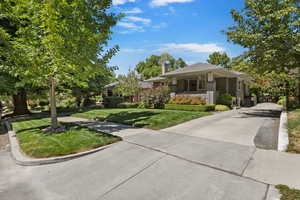 View of front of home with concrete driveway and a front lawn