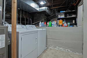Laundry area featuring washing machine and dryer and heating unit