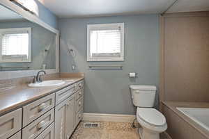 Bathroom featuring vanity, a bath, and light tile patterned floors