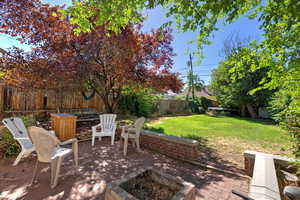 Fenced backyard featuring a patio and an outdoor fire pit