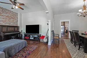 Living area with dark wood finished floors, a chandelier, and a ceiling fan