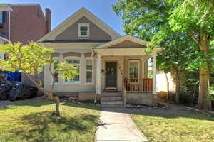 View of front of property featuring a porch, a front yard, and brick siding