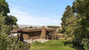 Rear view of property featuring mansard roof and brick siding