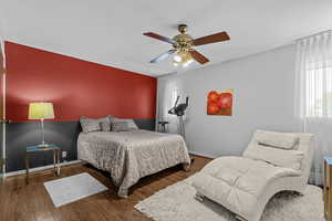 Bedroom with wood finished floors and ceiling fan