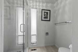 Bathroom featuring toilet and a stall shower