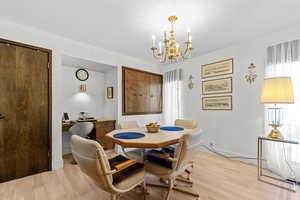 Dining area featuring light wood-style floors, a chandelier, and a desk
