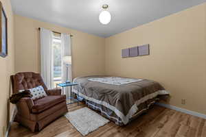 Bedroom with wood finished floors and baseboards