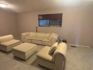 Living area with carpet and a textured ceiling