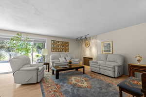 Living area featuring wood finished floors, a textured ceiling, and track lighting