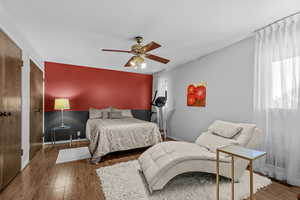 Bedroom with wood finished floors, a closet, and ceiling fan