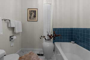 Full bathroom with toilet and a garden tub