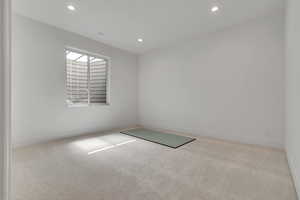 Carpeted empty room featuring recessed lighting and baseboards