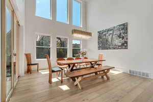 Dining room featuring a high ceiling and light wood-style floors