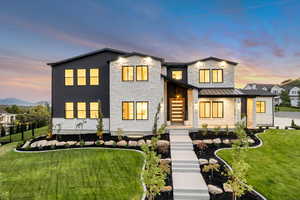 Contemporary house featuring a standing seam roof, stone siding, and a metal roof
