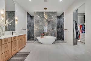 Bathroom with walk in shower, vanity, tile walls, a freestanding bath, and a spacious closet