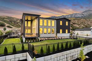 Rear view of property with a mountain view, a fenced backyard, and a trampoline