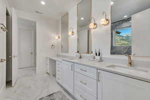Full bathroom featuring light marble finish flooring, double vanity, and recessed lighting