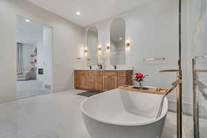 Full bath featuring double vanity, a soaking tub, and recessed lighting