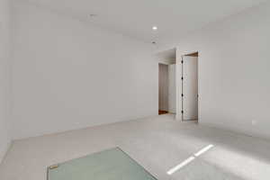 Carpeted empty room with recessed lighting and baseboards