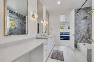Ensuite bathroom featuring vanity, light marble finish flooring, recessed lighting, and a combined bath / shower with marble appearance