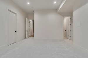 Hall with light carpet and recessed lighting