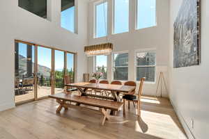 Dining room featuring a high ceiling, light wood-type flooring, plenty of natural light, and a mountain view