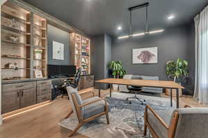 Office space with wood finished floors and recessed lighting
