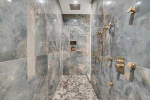 Bathroom featuring a marble finish shower