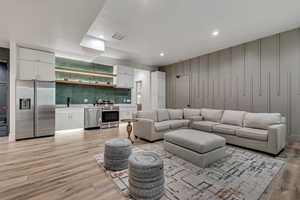 Living area with recessed lighting and light wood-type flooring