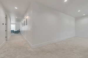Hallway featuring recessed lighting and light carpet